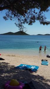 two people standing on a beach with the water at Apartments Meni in Drage