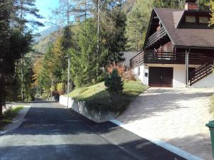 an empty road next to a house with a mountain at Holiday Home Gobela in Kranjska Gora