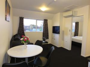 Cette chambre comprend une table, des chaises et un lit. dans l'établissement 101 Stars Motel, à Christchurch