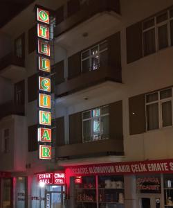 a sign in front of a building with neon signs at OTEL ÇINAR in Erzurum