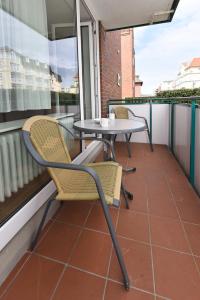 een patio met 2 stoelen en een tafel op een balkon bij Klippersteven in Wangerooge