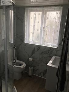 a bathroom with a sink and a toilet and a window at Lazydays Cottage in Moffat