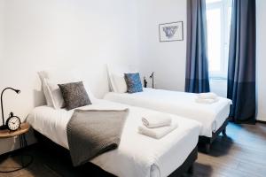 a bedroom with two beds with white sheets at LE 17 in Colmar