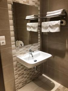 a bathroom with a sink and a mirror and towels at Hotel Costamar in El Morche