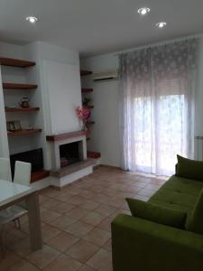 a living room with a green couch and a fireplace at Residence Monti in Scauri