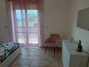 a bedroom with a bed and a chair next to a window at Residence Monti in Scauri