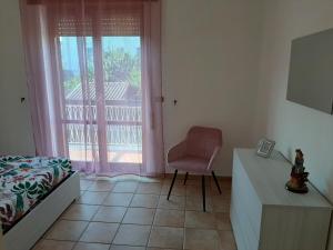 een slaapkamer met een bed en een stoel naast een raam bij Casa Monti in Scauri