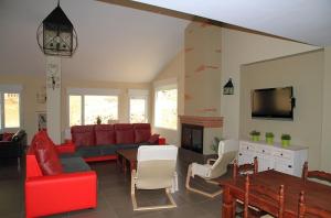 a living room with a red couch and a fireplace at Apartamentos Turísticos Rurales Monte de las Ánimas in Valdepeñas de Jaén