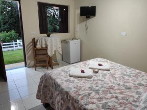 a bedroom with a bed with two pillows on it at Aconchego em Minas - Goncalves -Bairro Costas in Gonçalves