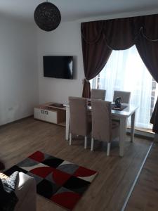 a living room with a table and chairs and a television at Iznad Oblaka A5 in Kopaonik