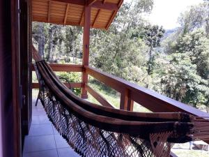 a hammock on the porch of a house at Aconchego em Minas - Goncalves -Bairro Costas in Gonçalves