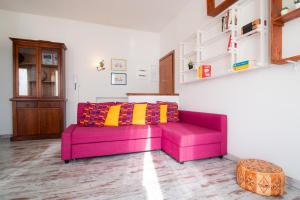 un sofá rosa con almohadas coloridas en la sala de estar. en Casina!, en Como