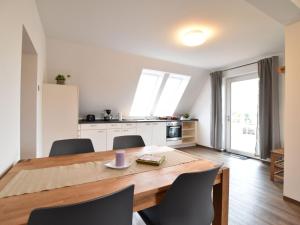 uma cozinha e sala de jantar com uma mesa de madeira e cadeiras em Scenic Apartment in Insel Poel with Terrace em Insel Poel