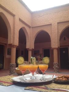 une table avec trois verres à vin sur une table dans l'établissement Riad Nkob, à Nkob