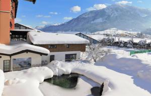 a building covered in snow with a pool of water at Vital & Sporthotel Brixen in Brixen im Thale