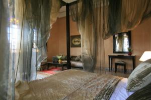 1 dormitorio con cama con dosel y mesa en Al Fassia Aguedal en Marrakech