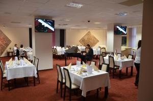 a woman playing a piano in a restaurant at Hotel CITY **** Galanta in Galanta