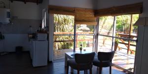 a kitchen with a table and chairs and a large window at Cabañas Burdeos in Tigre