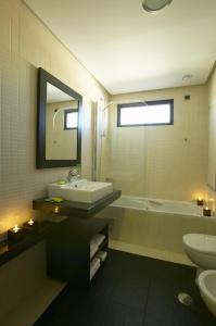 een badkamer met een wastafel, een bad en een toilet bij Hotel Lisboa in Lissabon