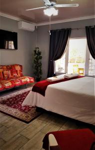 Un dormitorio con una cama grande y una ventana en Graceland Guesthouse, en Potchefstroom