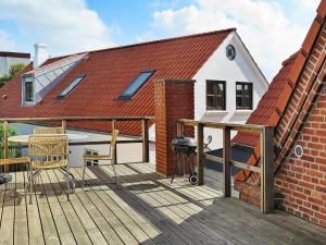 a deck with a grill and a house at Two-Bedroom Holiday home in Lemvig 5 in Lemvig