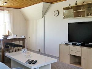 a living room with a tv and a table at Two-Bedroom Holiday home in Lemvig 5 in Lemvig