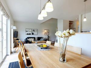 a dining room table with a vase of flowers on it at 6 person holiday home in Vejby in Vejby