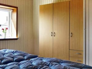 1 dormitorio con 1 cama, armario y ventana en Two-Bedroom Holiday home in Lemvig 5 en Lemvig