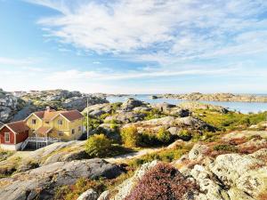 12 person holiday home in Sk rhamn في سكارهامن: منزل على الصخور بجانب الماء