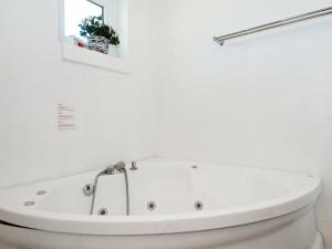 12 person holiday home in Eg في Åstrup: حوض استحمام أبيض في حمام أبيض