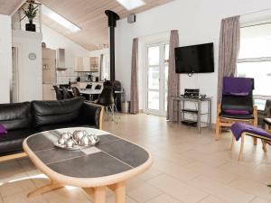 uma sala de estar com um sofá e uma mesa em 12 person holiday home in Eg em Åstrup