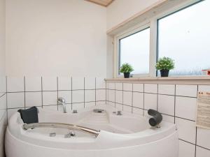 una vasca bianca in un bagno con finestra di 10 person holiday home in Glesborg a Fjellerup Strand