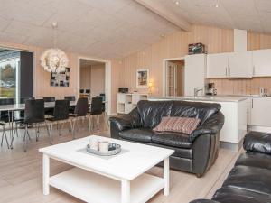 a living room with a leather couch and a table at 10 person holiday home in Glesborg in Fjellerup Strand