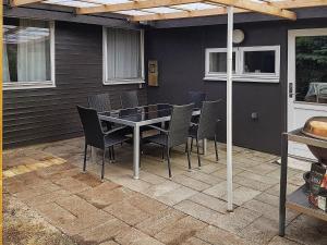 Une table à manger et des chaises sont disponibles sur la terrasse. dans l'établissement 7 person holiday home in Hals, à Hals