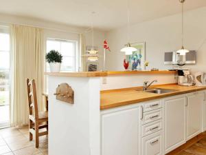 a kitchen with white cabinets and a sink at 8 person holiday home in Brenderup Fyn-By Traum in Bro +27 photos