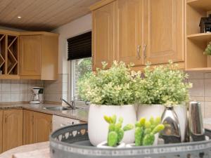 una cocina con dos jarrones blancos con plantas. en 9 person holiday home in Bl vand, en Ho