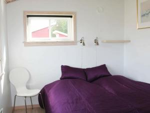グドイェムにあるHoliday Home Rø Skolevej IIIのベッドルーム(紫色のベッド1台、椅子付)