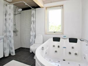 baño con bañera, aseo y ventana en 6 person holiday home in L kken, en Løkken