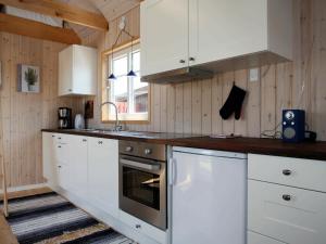 a kitchen with white cabinets and a stove top oven at 4 person holiday home in Karreb ksminde in Karrebæksminde