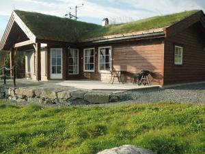 a small house with a grass roof with a patio at 7 person holiday home in Blaksæter-By Traum in Sølberg