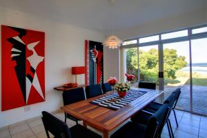 comedor con mesa de madera y sillas en Wilderness Beach Cottage, en Wilderness