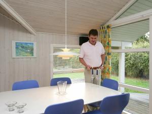 a man standing in a room with a table at 10 person holiday home in V ggerl se in Marielyst