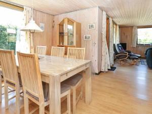 GrønhøjにあるThree-Bedroom Holiday home in Løkken 41のダイニングルーム(木製テーブル、椅子付)