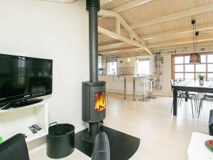 Il comprend un salon avec une cheminée et une télévision. dans l'établissement Three-Bedroom Holiday home in Frørup 3, à Tårup
