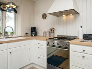 een keuken met witte kasten en een fornuis met oven bij 6 person holiday home in Bjert in Sønder Bjert