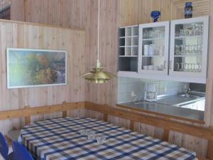 cocina con mesa a cuadros y fregadero en Three-Bedroom Holiday home in Idestrup 5, en Bøtø By