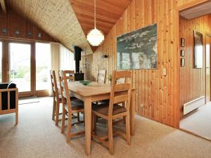 a dining room with a wooden table and chairs at Three-Bedroom Holiday home in Idestrup 3 in Marielyst