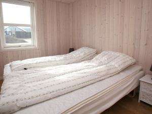 2 camas sin hacer en una habitación con ventana en Three-Bedroom Holiday home in Løkken 40, en Løkken