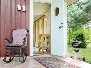 una silla sentada en el porche de una casa en 4 person holiday home in M nster s, en Mönsterås