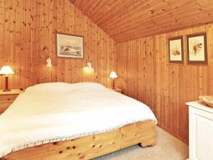 a bedroom with a bed in a wooden room at Three-Bedroom Holiday home in Idestrup 3 in Marielyst